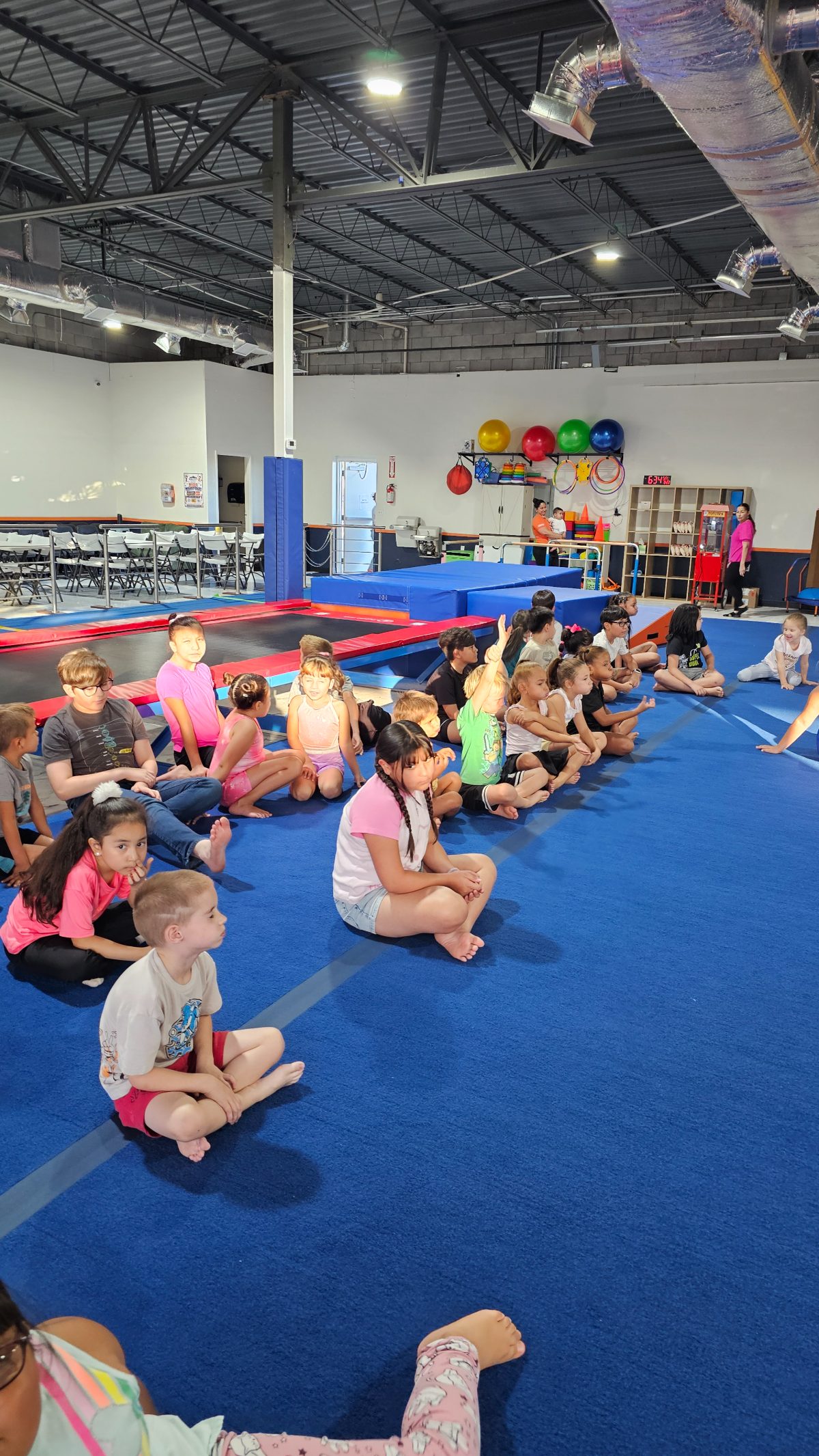 A big group of kids gathered on the floor for a game at Kids Night Out