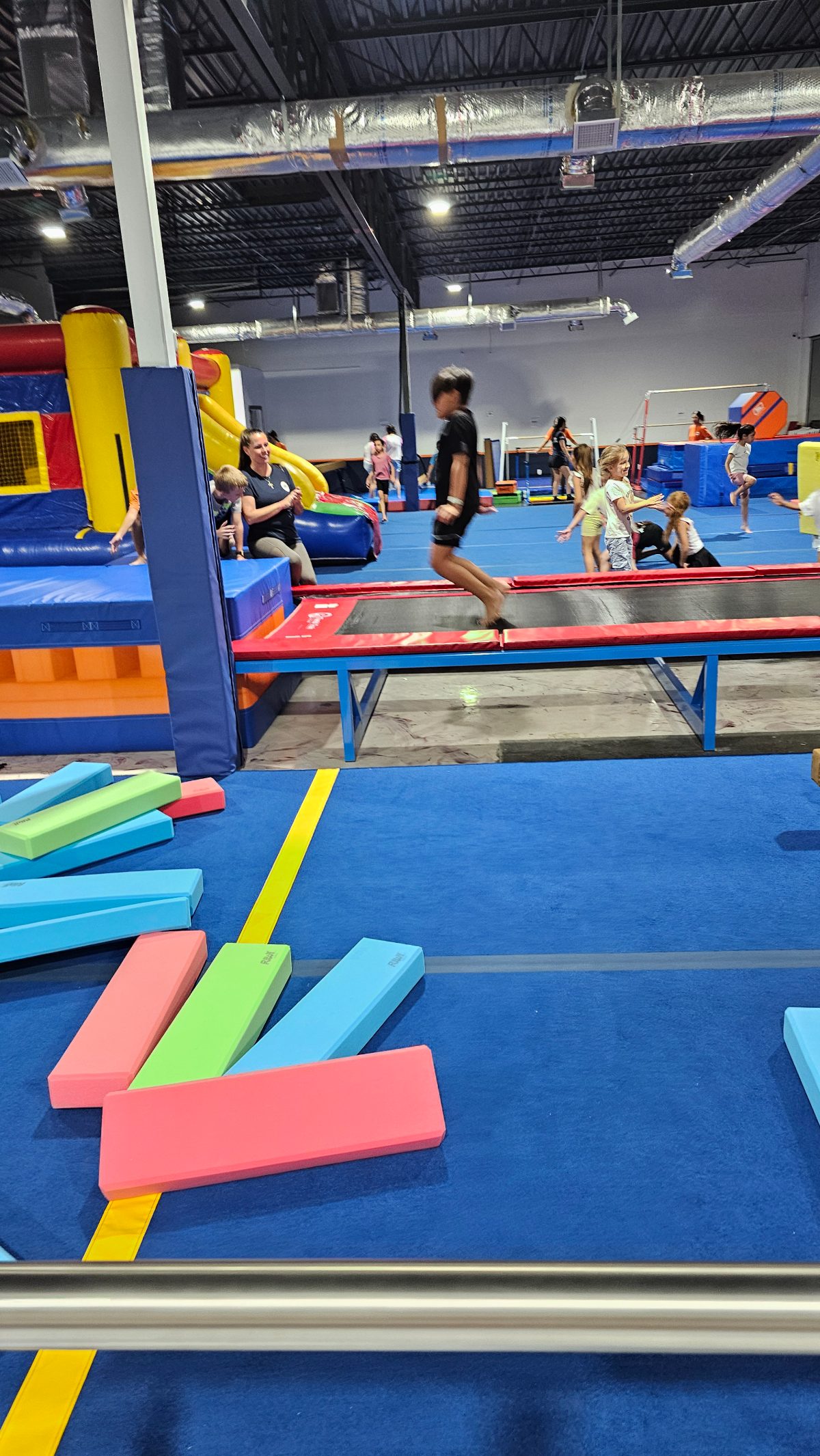 Kids running and playing on the trampoline and bounce house at Kids Night Out